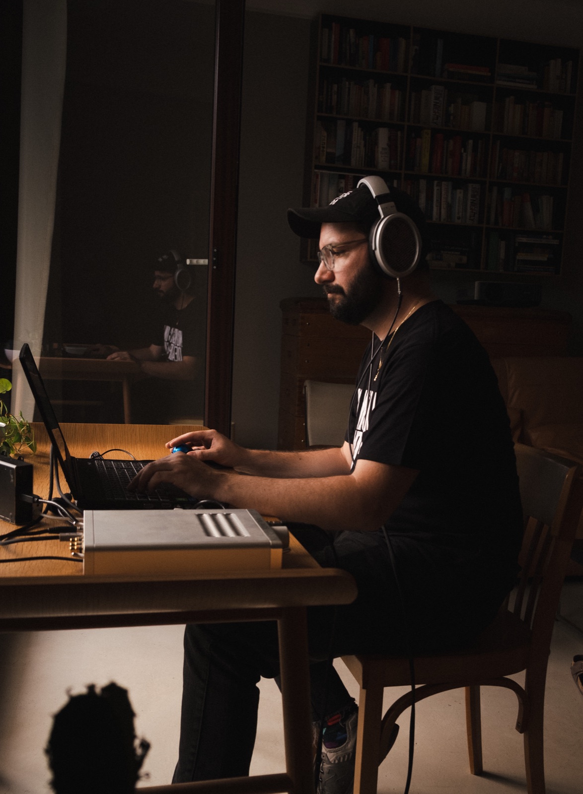 Flo Siller at his laptop wearing headphones, an amplifier in front of him